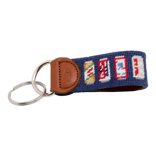 Hand-stitched Beer Can needlepoint keychain showing popular beer can pattern on both sides against a navy blue background and leather backing.  Stainless steel D-ring and keyring.