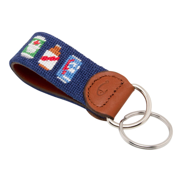 Hand-stitched Beer Can needlepoint keychain showing popular beer can pattern on both sides against a navy blue background and leather backing.  Stainless steel D-ring and keyring.