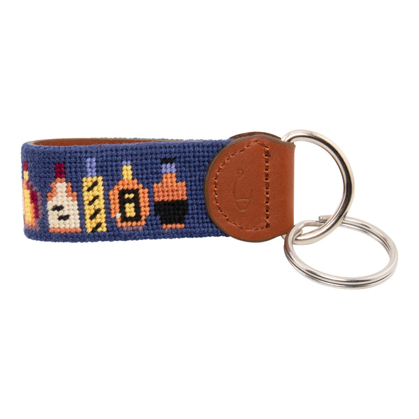 Hand-stitched bluefin tuna needlepoint keychain showing a bluefin tuna on both sides against a light blue background and leather backing.  Stainless steel D-ring and keyring.