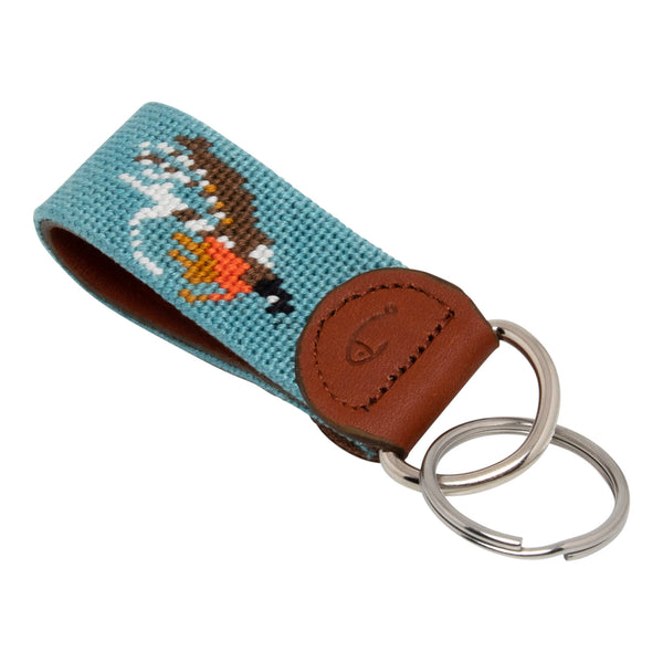 Hand-stitched Fly Fishing needlepoint keychain showing a fly fishing trout fly pattern on both sides against a light blue background and leather backing.  Stainless steel D-ring and keyring.