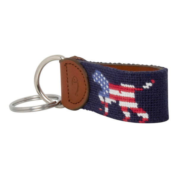 Hand-stitched Patriotic Dog needlepoint keychain showing an American Flag colored dog on both sides against a navy blue background and leather backing.  Stainless steel D-ring and keyring.