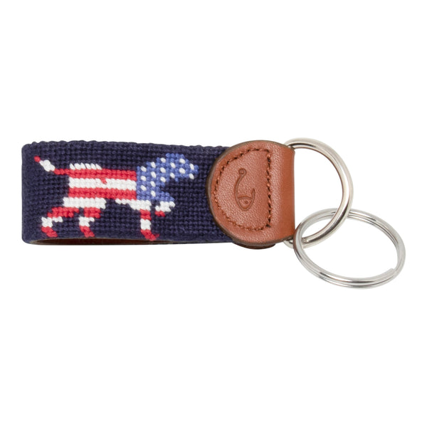 Hand-stitched Patriotic Dog needlepoint keychain showing an American Flag colored dog on both sides against a navy blue background and leather backing.  Stainless steel D-ring and keyring.