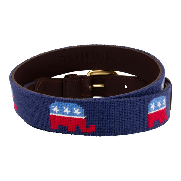 Republican needlepoint belt with a navy blue background showing a repeating pattern of evenly spaced republican elephant logos.  Belt has a brass buckle and full grain leather backing and strap.