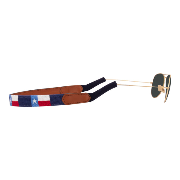 Side View Texas Flag needlepoint sunglass strap showing the Texas Flag against a navy blue background with sturdy cotton covered silicone ear connectors and a soft leather backing